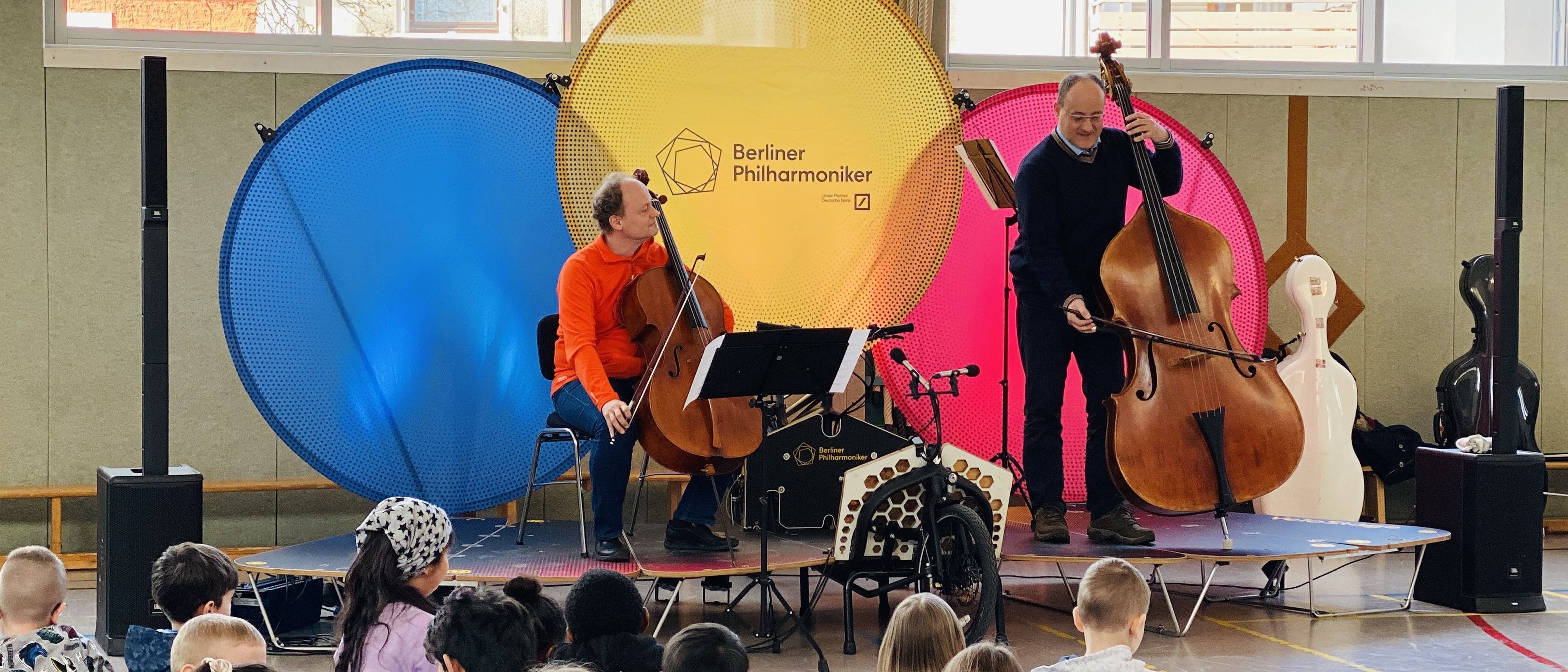 Two musicians on the mobile bicycle stage with the audience in the foreground